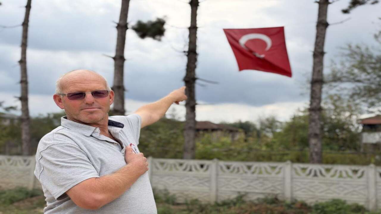 Türk bayrağını düzeltmek için iş makinesinin kepçesine çıktı