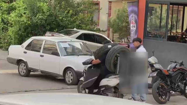 Ankara'da kurye lastikleri boynuna ve motosikletine asarak trafiği riske attı