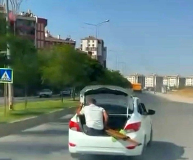 Diyarbakır'da bagaj kapısında oturan çocuk ve malzeme taşıyan kişi görüntülendi