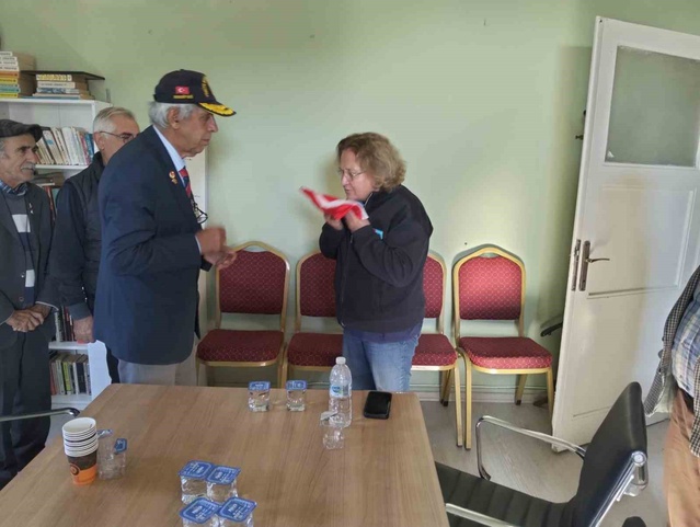Ayvalık'ta Kent Konseyi Başkanı Atay, gazilerden gelen Türk Bayrağı'nı öpüp başına koydu
