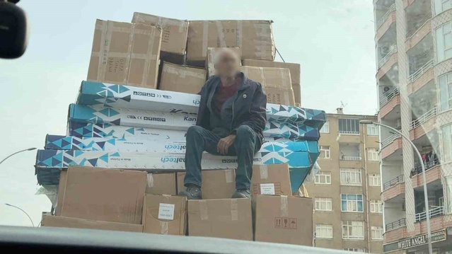 Diyarbakır'da kolilerin üzerinde oturarak yolculuk eden kişi kameralarca görüntülendi