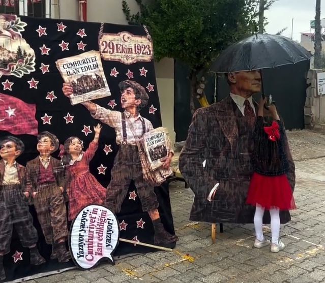 Hatay'da Cumhuriyet Bayramı töreninde yağmura yakalanan Atatürk maketini 2. sınıf öğrencisi şemsiyesiyle korudu