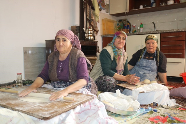 Denizli Çivril'de kadınlar kışlık ekmek için bir çuval unu imeceyle yufkaya çevirdi