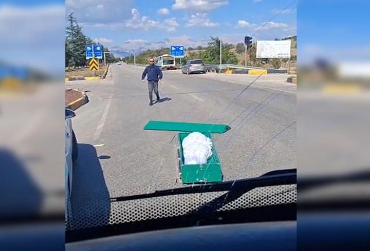 Seyir halindeki cenaze nakil aracından yola tabut düştü