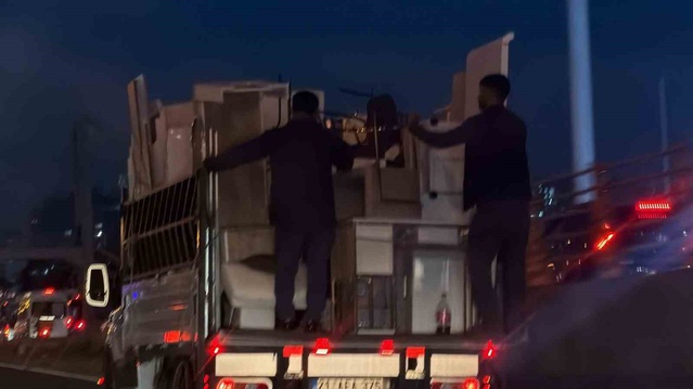 Diyarbakır'da eşyalar düşmesin diye kamyonet kasasına tutunan iki kişi görüntülendi